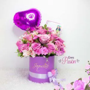 Arreglo floral "Eres Pasión" con rosas y flores en tonos rosados y lilas en caja lila personalizada con globo en forma de corazón y tarjeta.