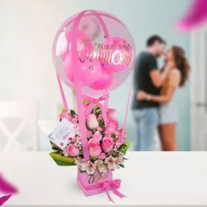 Arreglo floral con rosas color fucsia y un globo de burbuja transparente con mensaje de 'Feliz Cumpleaños', perfecto para celebraciones.