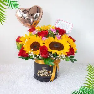 Arreglo de girasoles y rosas rojas con globo en forma de corazón y mensaje 'Te quiero mucho', perfecto para expresar amor.