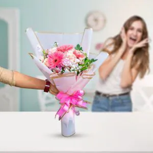 Ramo de flores frescas con gerberas rosas y follaje, entregado con alegría por Florería Amalia en Lima.