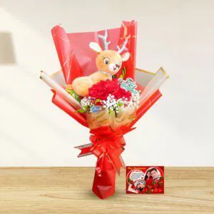 Ramo navideño con un peluche de reno y rosas rojas, acompañado de una tarjeta festiva, de Florería Amalia.