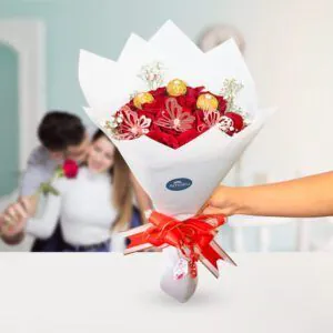 Ramo de rosas rojas y Ferrero Rocher con una elegante cinta roja, ideal para un romántico detalle de Florería Amalia.