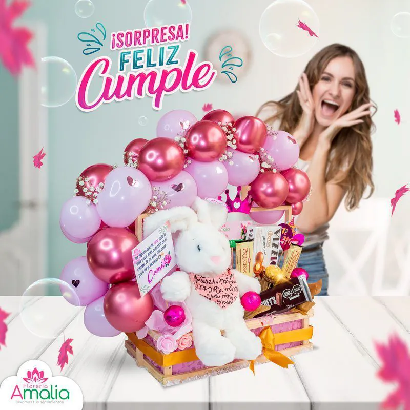 Arreglo de cumpleaños con globos rosados y dorados, un peluche de conejo y una caja de chocolates, ideal para una sorpresa festiva y amorosa.