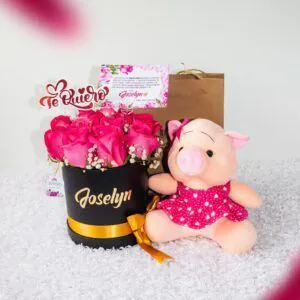 Arreglo de rosas fucsias en caja personalizada con nombre 'Joselyn' y un peluche de cerdita, ideal para demostrar cariño y afecto.