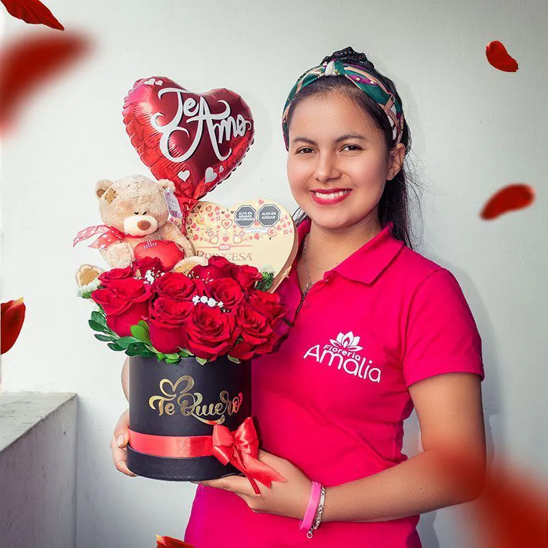 Persona sosteniendo una caja con rosas rojas, osito de peluche, chocolates y globo "Te Amo". 🌹🐻🍫❤️