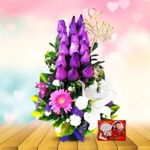 🌹 Arreglo floral "Rosas Lila" con rosas en tono lila, lirios blancos, gerbera y topper "Love." Un regalo romántico con globo "Feliz Aniversario."