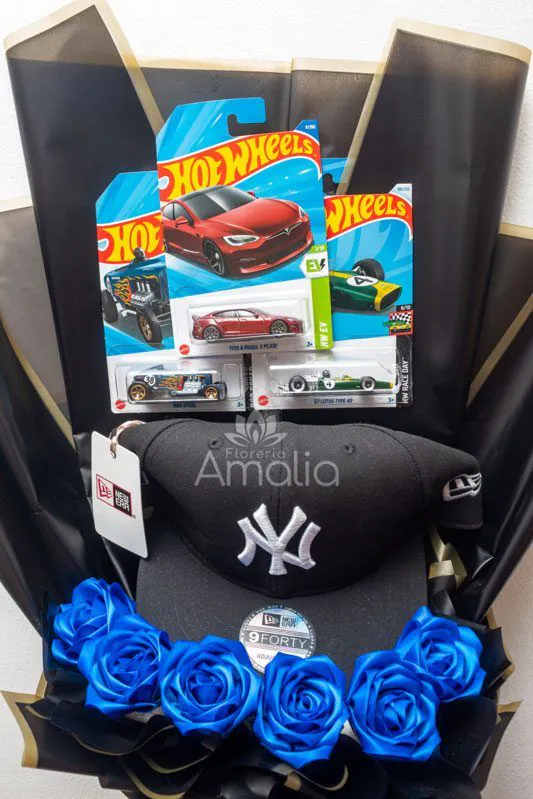 Ramo decorativo con autos Hot Wheels, gorra NY y rosas azules, ideal para regalos temáticos y personalizados para hombres.