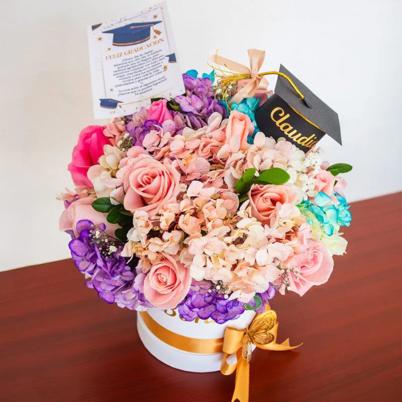 Arreglo floral de graduación en caja personalizada con detalles únicos y nombre grabado.