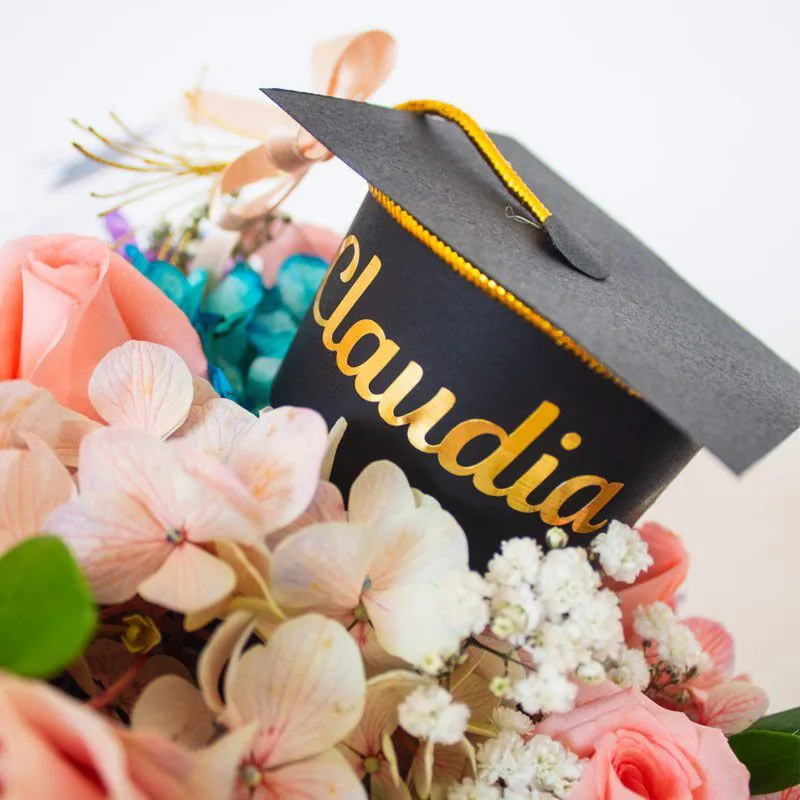Arreglo floral de graduación en caja personalizada con detalles únicos y nombre grabado.