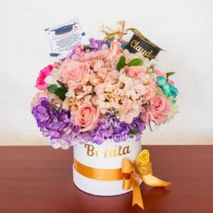 Arreglo floral de graduación en caja personalizada con detalles únicos y nombre grabado.