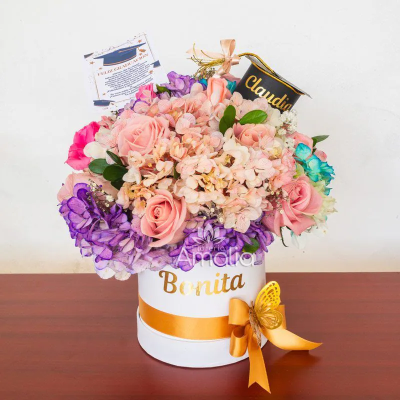 Arreglo floral de graduación en caja personalizada con detalles únicos y nombre grabado.