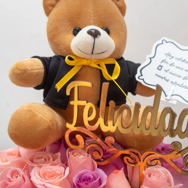 Caja decorativa con rosas rosadas y osito graduado, ideal para celebrar logros académicos con estilo y elegancia