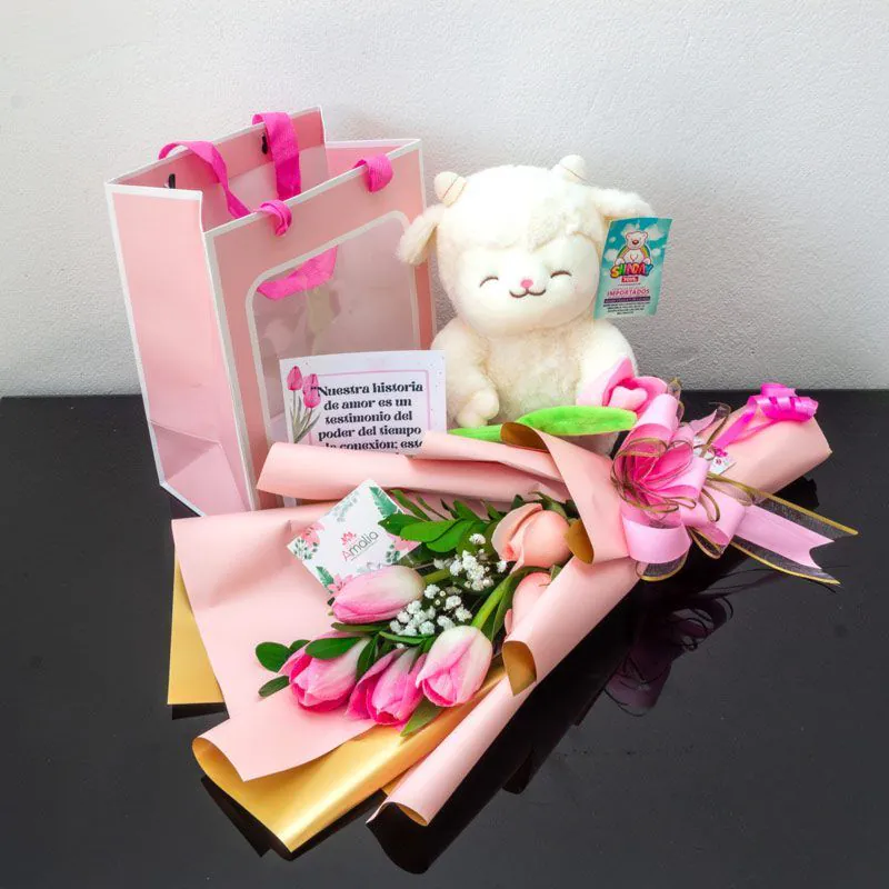 Set romántico con ramo de tulipanes rosados, peluche de oveja blanca y tarjeta personalizada en bolsa decorativa.