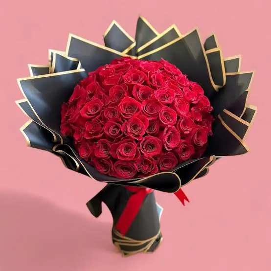 Ramo de 75 rosas rojas naturales envuelto en papel negro con bordes dorados, ideal para sorprender con un regalo elegante y apasionado.