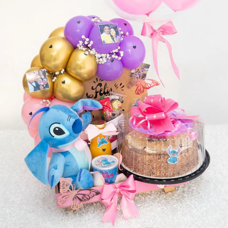 “Cumpleaños sorpresa con peluche Stitch, torta decorada, globo burbuja, arco de globos y fotos personalizadas sobre base, ideal para regalar.”