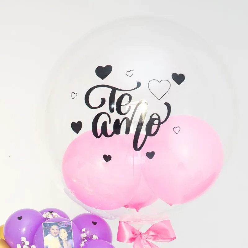 “Cumpleaños sorpresa con peluche Stitch, torta decorada, globo burbuja, arco de globos y fotos personalizadas sobre base, ideal para regalar.”