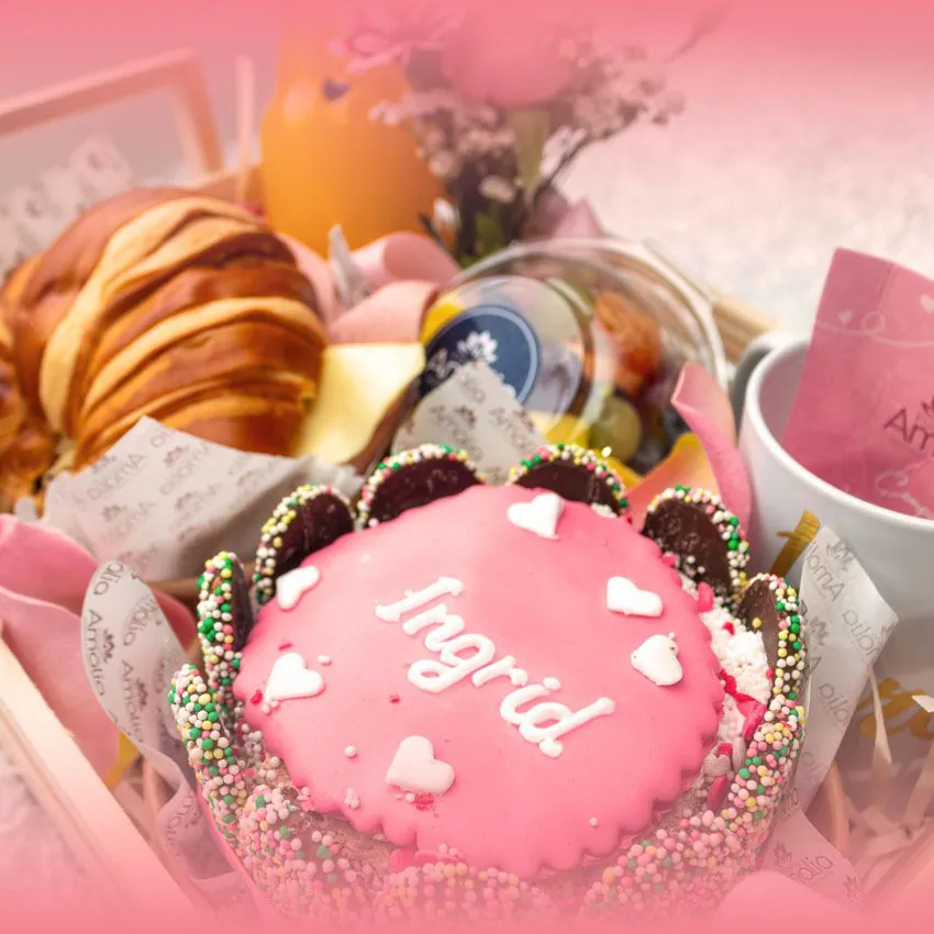 Desayuno sorpresa en fuente de madera con mini torta personalizada, pan brioche, jugo, frutas, taza y mini florero – Florería Amalia.