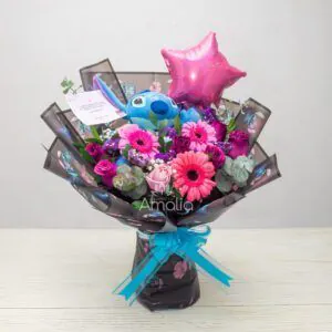 Ramo de cumpleaños con peluche Stitch, gerberas y rosas en tonos rosa, globo estrella y follaje de eucalipto – Florería Amalia.