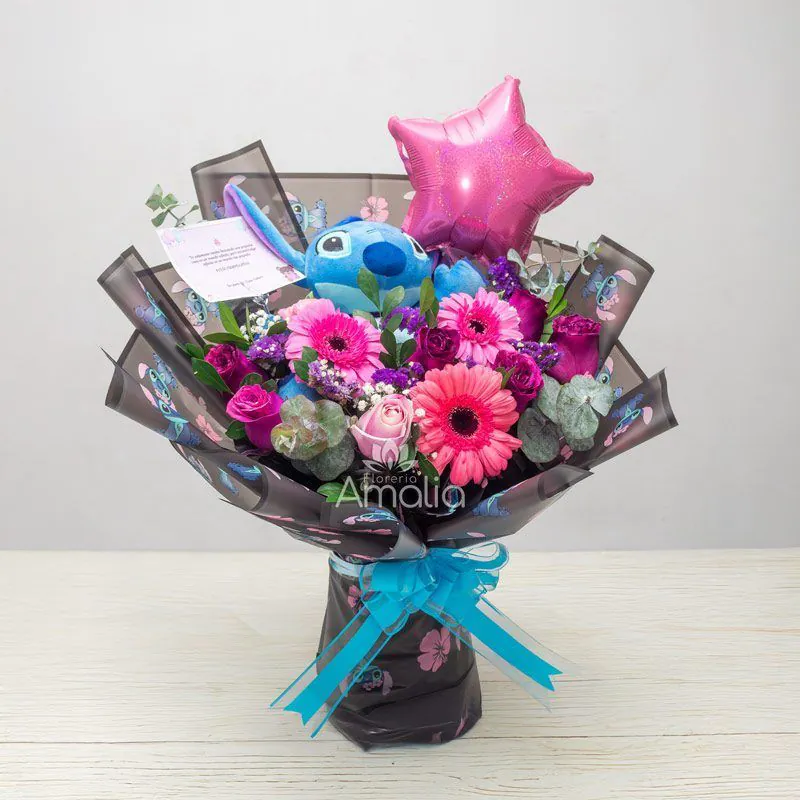 Ramo de cumpleaños con peluche Stitch, gerberas y rosas en tonos rosa, globo estrella y follaje de eucalipto – Florería Amalia.