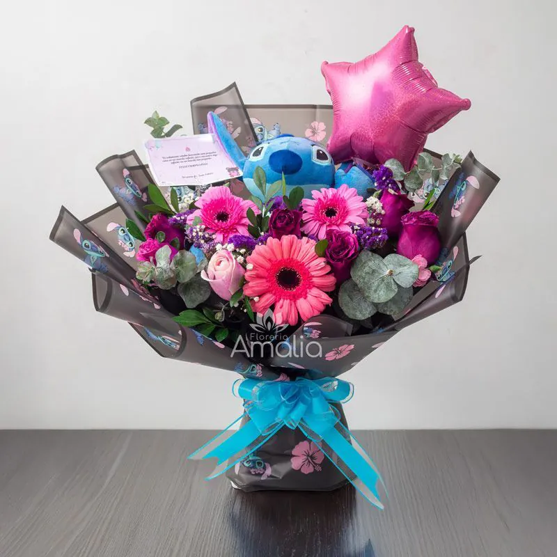 Ramo de cumpleaños con peluche Stitch, gerberas y rosas en tonos rosa, globo estrella y follaje de eucalipto – Florería Amalia.