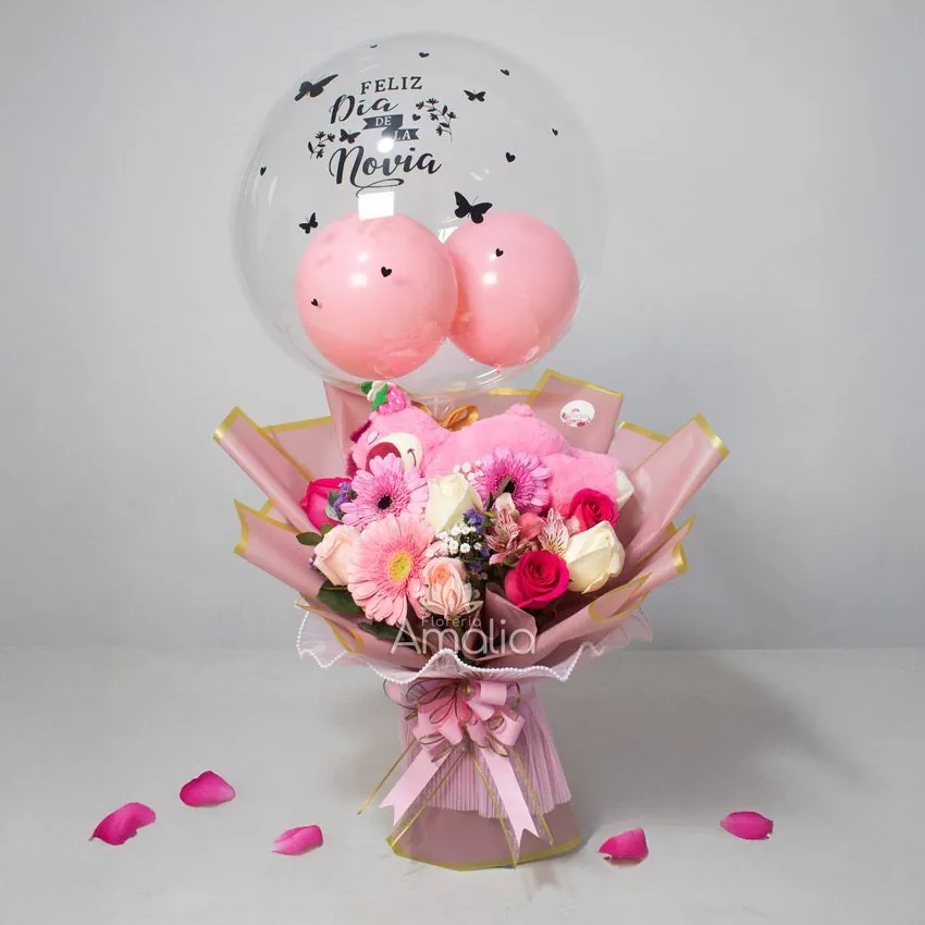 Arreglo con globo burbuja “Feliz Día de la Novia”, peluche rosado y bouquet de gerberas y rosas en tonos pastel.