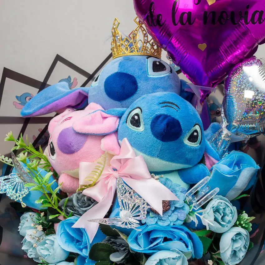 Ramo con peluches Stitch y Angel, rosas azules, mariposas brillantes y globo corazón “Feliz Día de la Novia”.
