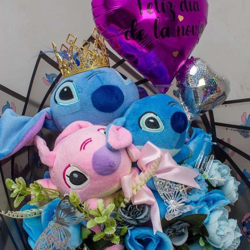 Ramo con peluches Stitch y Angel, rosas azules, mariposas brillantes y globo corazón “Feliz Día de la Novia”.