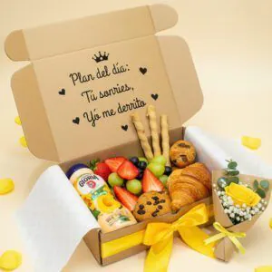 Desayuno con flores amarillas: mini ramo de rosa amarilla, fruta fresca, croissant y bocadillos en caja con la frase Plan del día