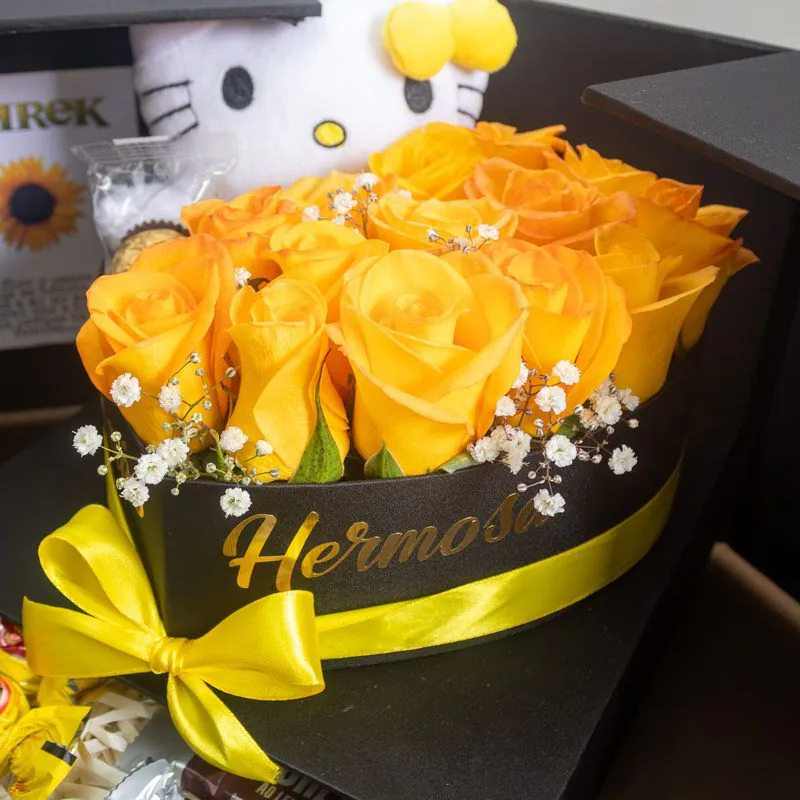 Detalle de rosas amarillas con peluche y chocolates en caja sorpresa premium