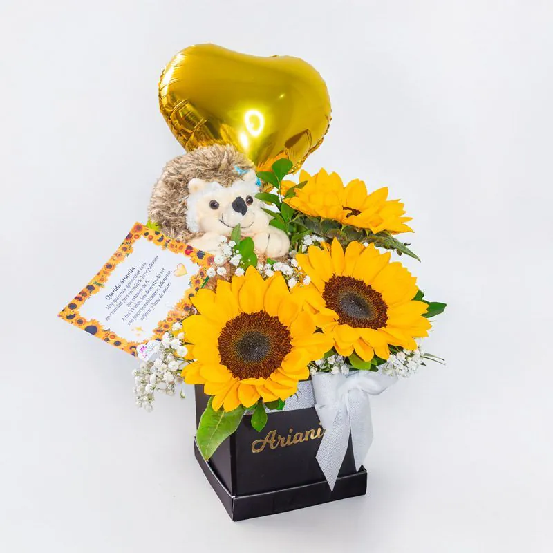 Caja negra con 3 girasoles, peluche erizo y globo corazón dorado
