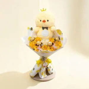 Bouquet amarillo con patito de peluche, rosas amarillas y Ferrero Rocher sobre fondo neutro.