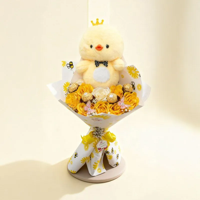 Bouquet amarillo con patito de peluche, rosas amarillas y Ferrero Rocher sobre fondo neutro.