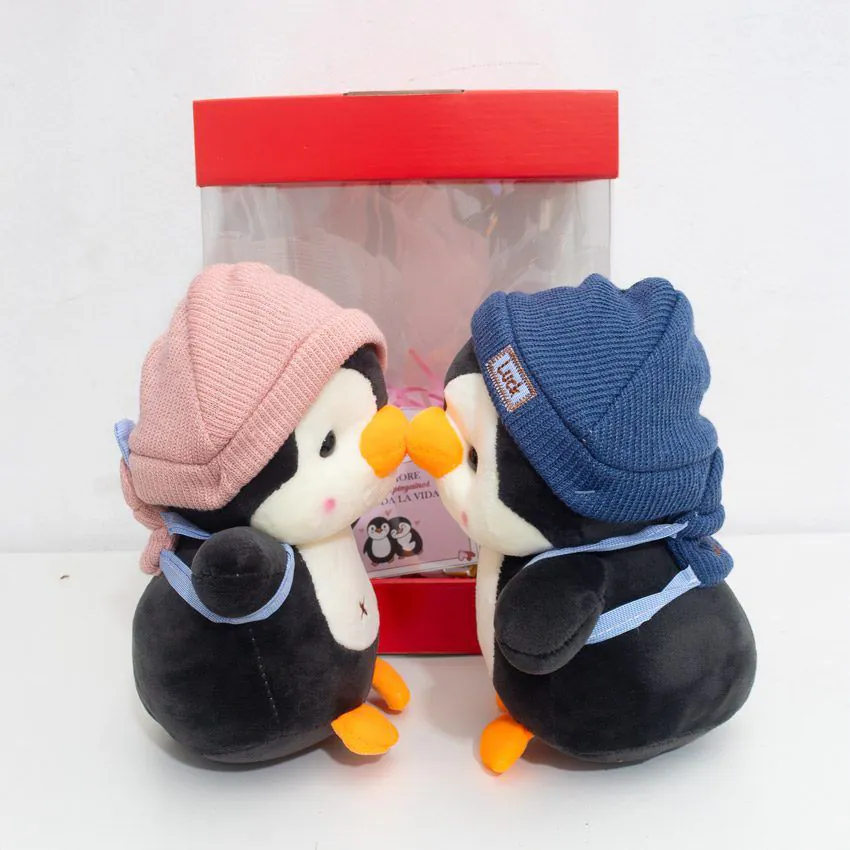 Pareja de pingüinos de peluche personalizados con nombres estampados en los gorros y fecha de aniversario en el pecho.
