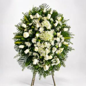 Corona fúnebre blanca con rosas, hortensias y follaje verde de Florería Amalia