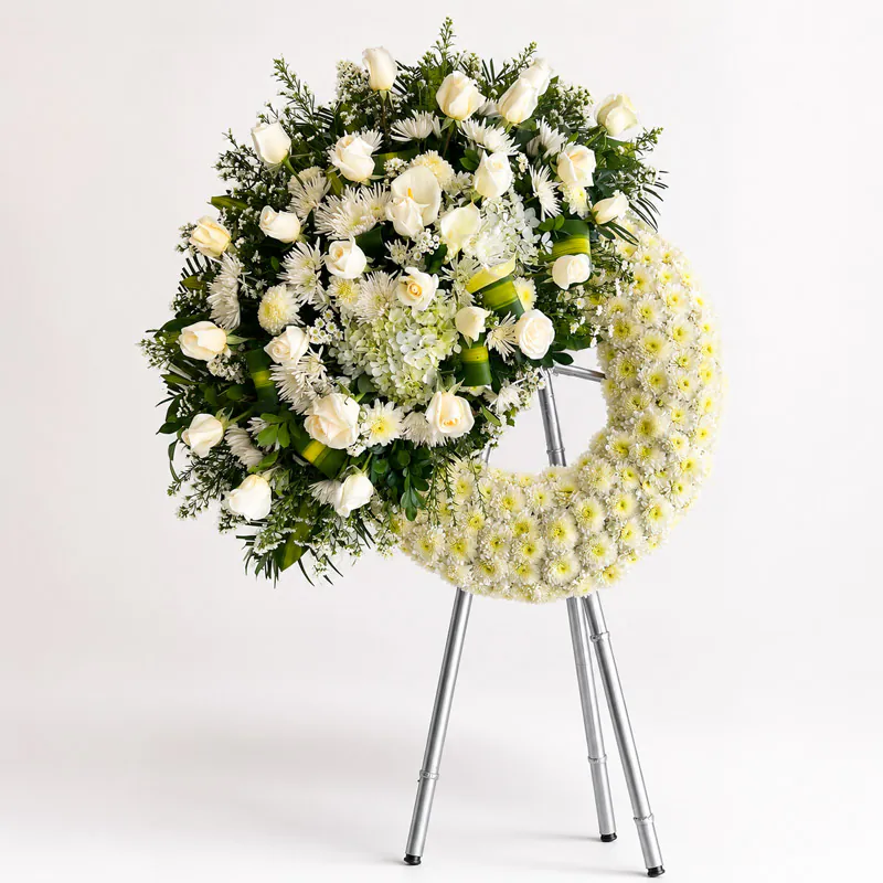Corona fúnebre media luna con rosas blancas, hortensias y flores blancas de Florería Amalia