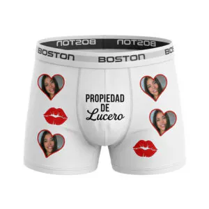 Acercamiento a bóxer blanco marca Boston personalizado con la frase Propiedad de Lucero, besos rojos y múltiples fotos del rostro de la novia en marcos de corazón.