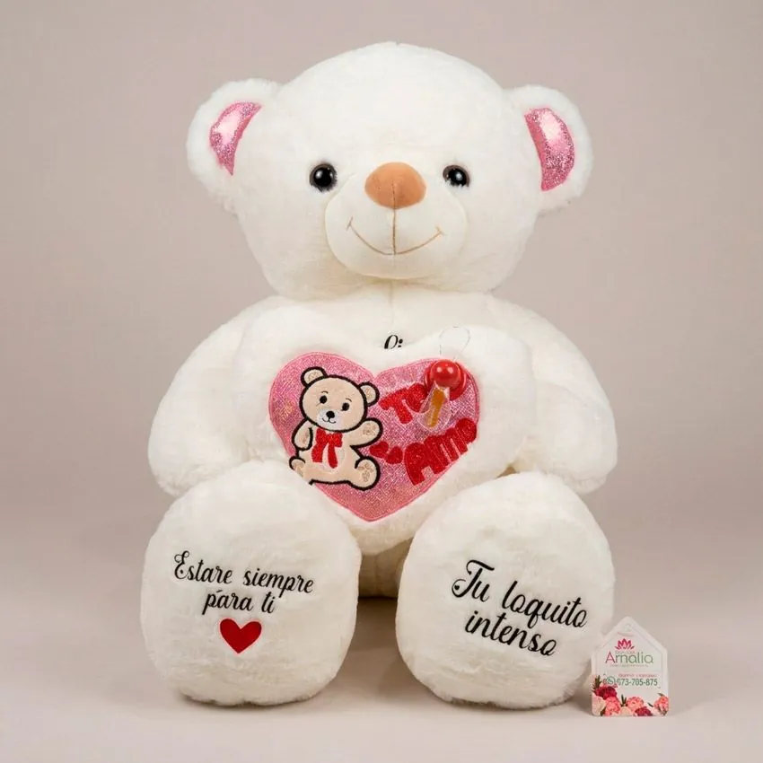 Oso de peluche blanco sosteniendo un corazón que dice Te Amo, con orejas brillantes y mensajes románticos personalizados estampados en las patas.