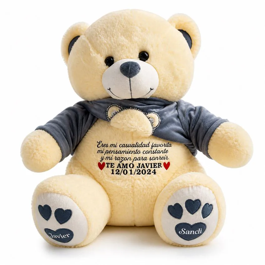 Oso de peluche con polera gris azulado levantada, revelando una dedicatoria de amor secreta en el vientre y huellas personalizadas con los nombres Javier y Sancli.