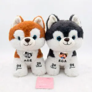 Pareja de peluches de perrito husky personalizados con foto de pareja en el pecho, iniciales y fechas de aniversario en las patitas.