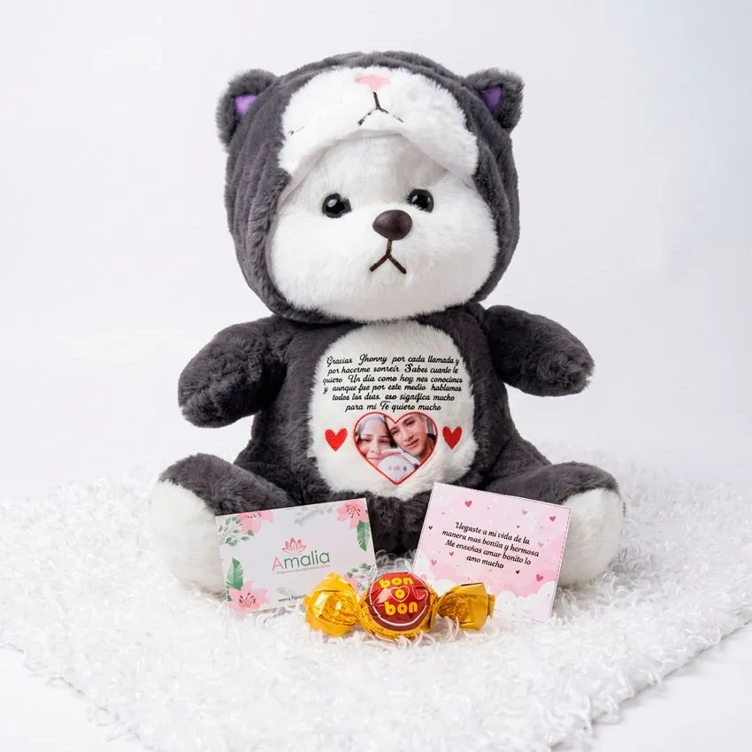 Peluche de gatito gris personalizado con foto en forma de corazón y carta de amor, acompañado de tarjetas de dedicatoria de Florería Amalia y chocolates Bon o Bon.