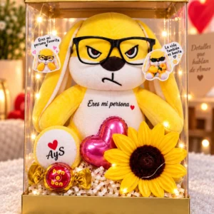 Conejo amarillo con lentes y girasol en caja transparente, 35 cm.