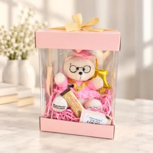 Osita con lentes y traje rosa, chocolate Princesa, globo estrella y tarjetas. En caja transparente rosa.