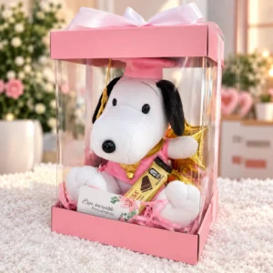 Snoopy graduado con traje rosa, chocolate Princesa, globo estrella y tarjeta. En caja transparente con lazo.