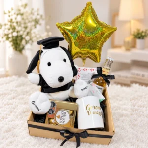 Snoopy graduado, taza, bebida en botella, chocolates Ferrero Rocher, globo estrella y tarjetas. Caja con lazo negro.