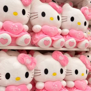 Peluches Hello Kitty con vestido rosado, corazones y lazos; precio por unidad.