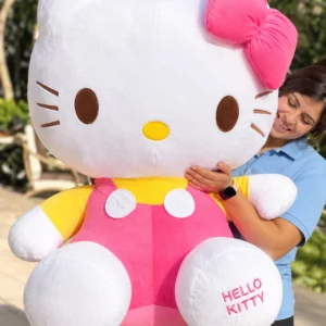 Hello Kitty con lazo fucsia, overol rosa y camiseta amarilla.