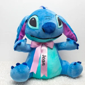 Peluche Stitch azul con barriga celeste y lazo grande.