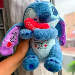 Peluche Stitch azul con corazón rojo entre los brazos.