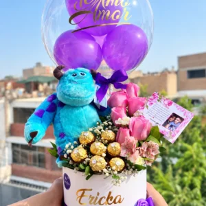 Sulley Encantador: Sulley de peluche, rosas rosadas, flores de acompañamiento y chocolates de envoltura dorada en box.